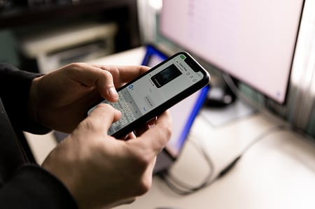 person using smartphone, indicating a security risk and in need of privacy training